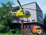 Als Werbetrger vor dem Feuerwehrmuseum in Berlin-Reinickendorf, OT Tegel. Berlins erster Rettungshubschrauber, Christoph 31, und ein an die Hauswand montierter, aufgeschnittener Rettungswagen der Berliner Feuerwehr. Foto: 26.6.2007 