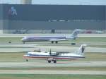 Eine ATR 42 der American Eagle beim Start, whrend im Hintergrund eine MD-83 der American nach der Landung abbremst. (Dallas Fort Worth, 24.07.2009)